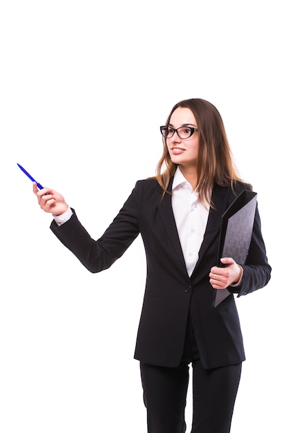 Full body picture of a smiling business woman presenting something on the back with hand holding marker. Isolated over white wall