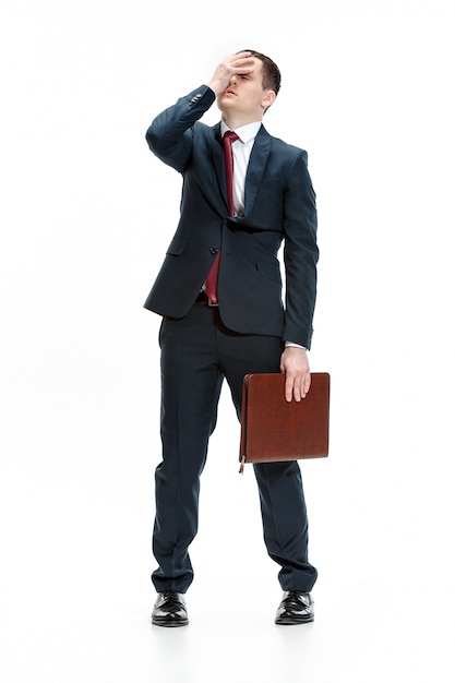 Full body portrait of businessman with folder on white wall
