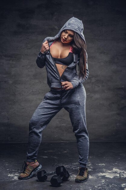 Full body studio portrait of dapper sexy female in grey hoodie.