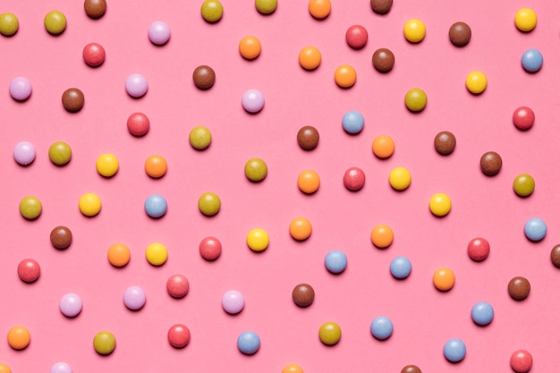 Free photo full frame of colorful multicolored gem candies on pink background