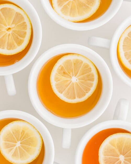 Full frame of lemon herbal tea in cups on white backdrop