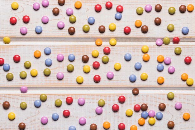 Полный кадр из разноцветных драгоценных конфет на деревянный стол