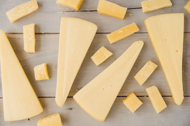 Free photo full frame of triangular and cube cheese on wooden desk