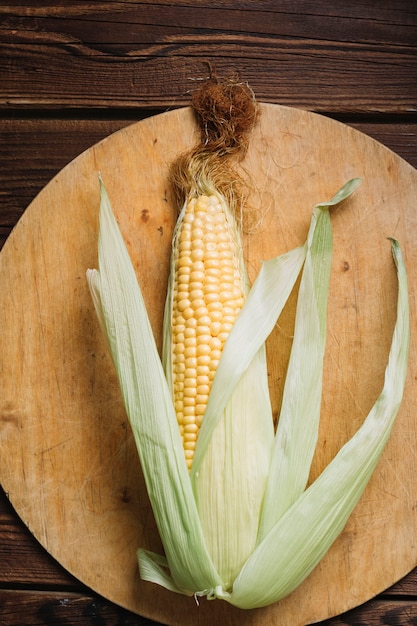 Free photo full grown corn with leaves on a cutting board