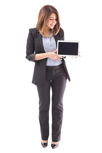 Full lenght portrait of a beautiful sales executive holding a tablet computer and looking at the screen