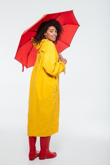 Full length back view image of smiling african woman