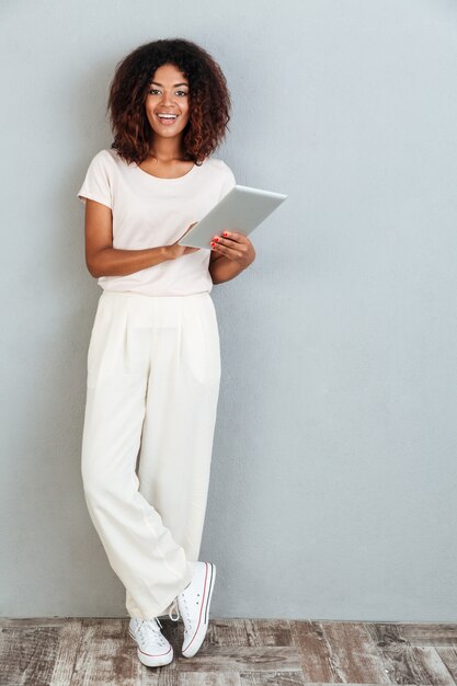 Full length of a casual smiling afro american woman standing