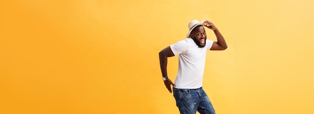 Full length of handsome young black man jumping against yellow background