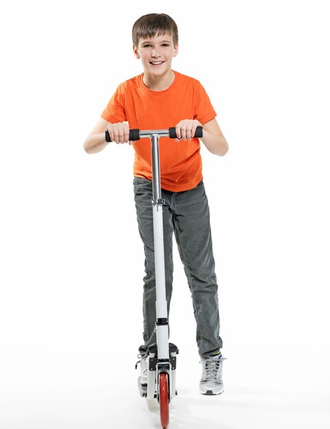 Full length  of a happy kid riding a scooter isolated on white background