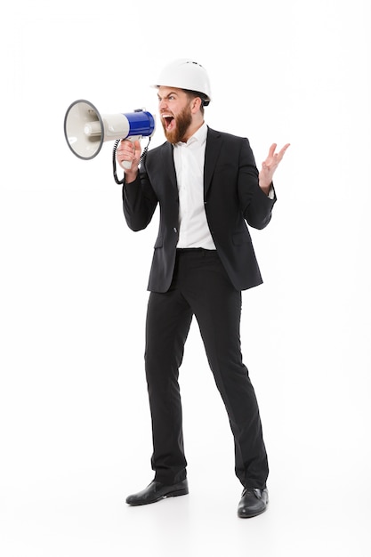 Full length image of Angry business man in protective helmet