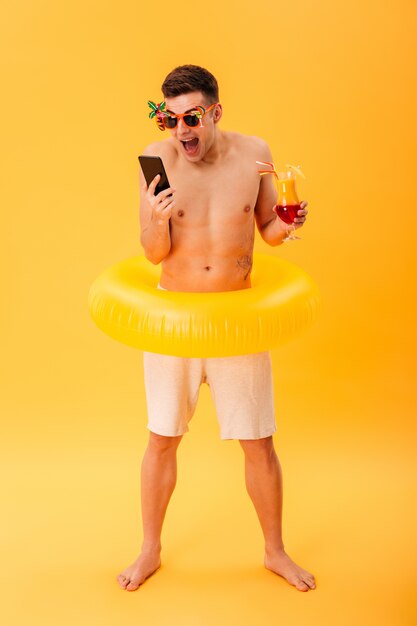 Full-length image of Angry naked man in shorts and sunglasses