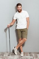 Full length image of a bearded man posing with club