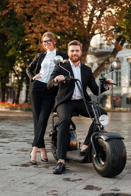 Full length image of Smiling business couple posing