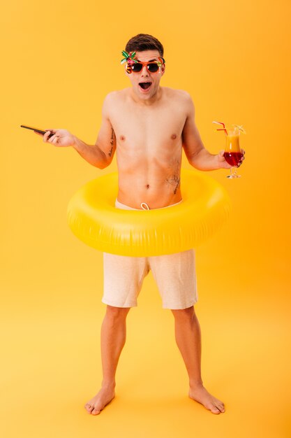 Full-length image of Surprised naked man in shorts and sunglasses