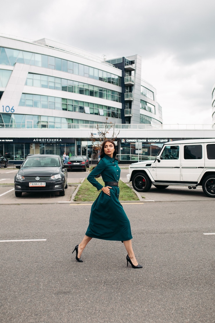 Free Photo full length photo of attractive young woman with long hair walking on street in the city while looking away. city lifestyle