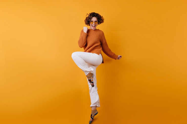Free Photo full-length photo of elegant european female model dancing with excitement