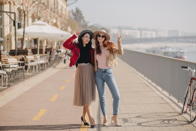 Full-length photo of slim ginger woman in casual clothes spending weekend with friend