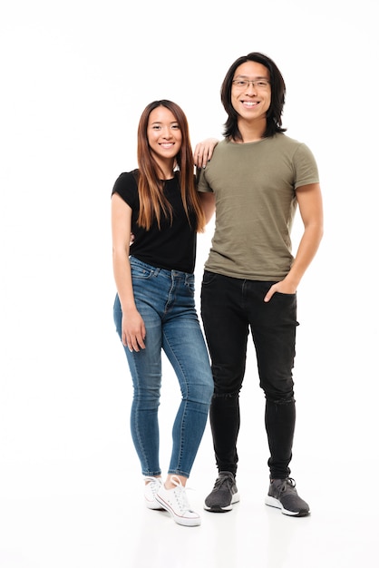 Full length photo of young charming asian couple in casual wear looking at camera