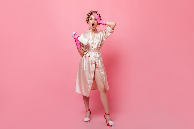 Full-length picture of woman in silk robe and pink rubber gloves