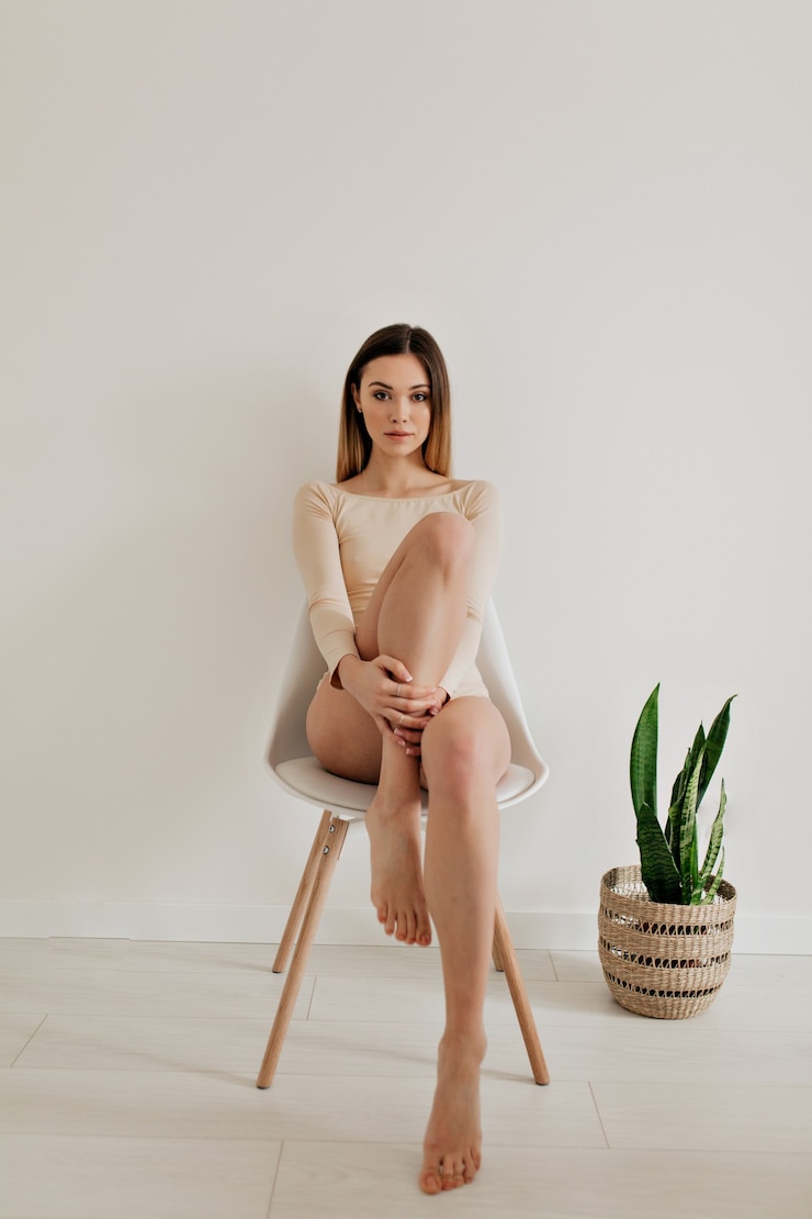 Free Photo full-length portrait of attractive pretty european woman wearing beige body with natural make up and blond hair posing at camera over white wall