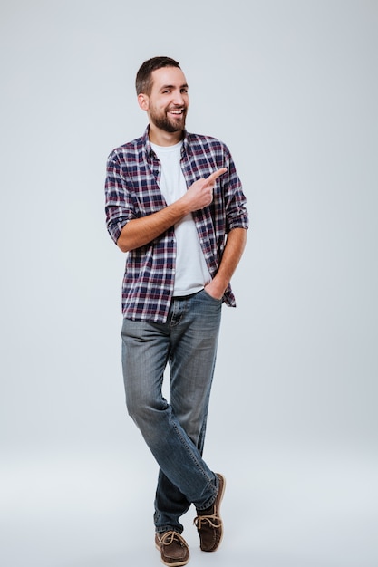 Free photo full length portrait of bearded man in shirt pointing away