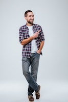 Full length portrait of bearded man in shirt pointing away