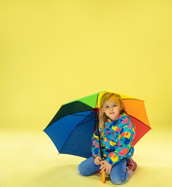 A full length portrait of a bright fashionable girl in a raincoat