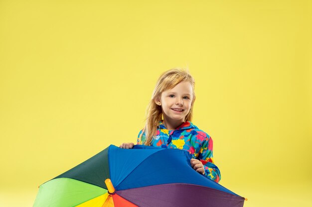 A full length portrait of a bright fashionable girl in a raincoat