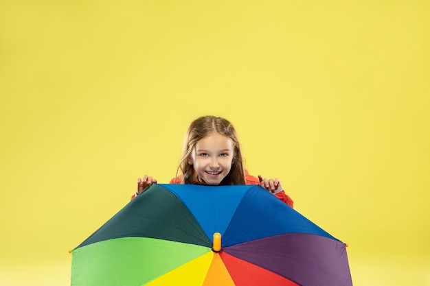 A full length portrait of a bright fashionable girl in a raincoat