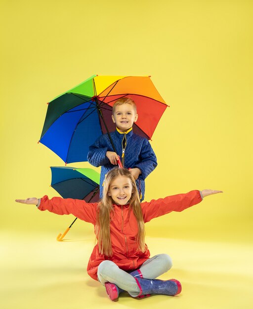 A full length portrait of a bright fashionable kids in a raincoat