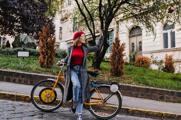 Full-length portrait of carefree young woman in vintage denim pants posing on beautiful nature background