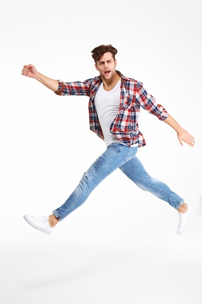 Free photo full length portrait of a casual young man jumping