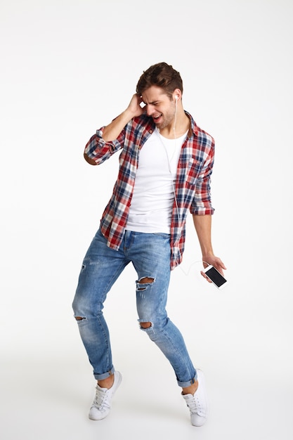 Free photo full length portrait of a cheery young man with earphones