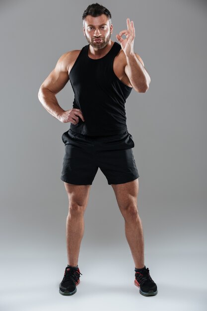 Full length portrait of a concentrated strong male bodybuilder