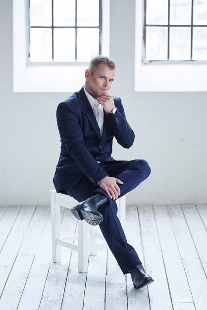 Full length portrait of confident mature businessman in formals standing isolated over white background