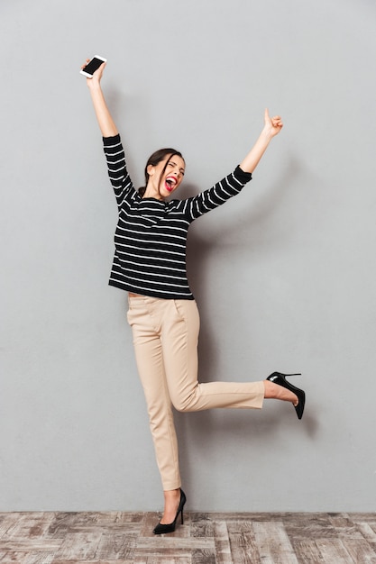 Free photo full length portrait of an excited woman