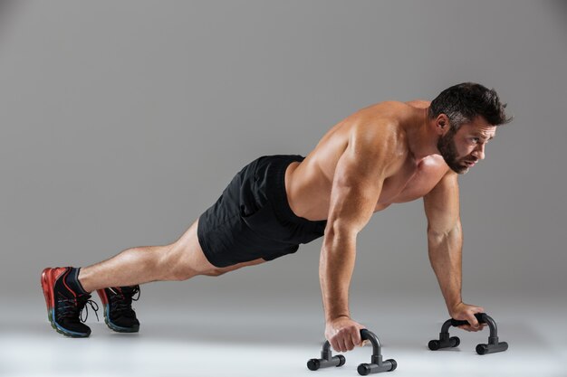 full length portrait of a fit strong shirtless male bodybuilder