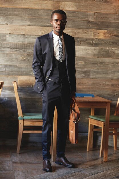 Full-length portrait of handsome African businessman wearing elegant formal suit