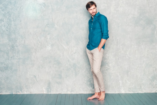 Full length portrait of handsome confident hipster lumbersexual businessman model wearing casual jeans shirt clothes. 