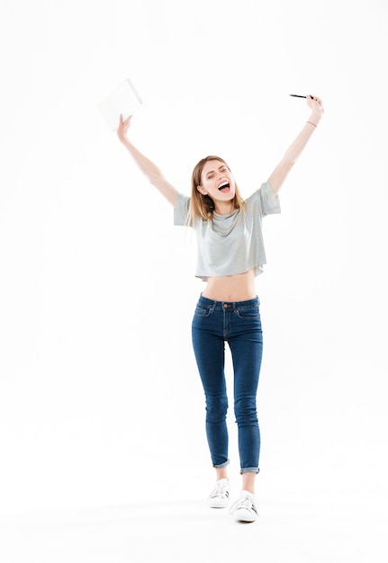 Full length portrait of a happy cheerful girl holding notepad