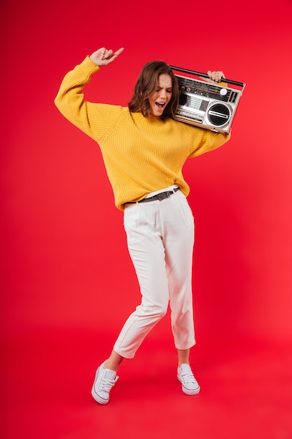 Full length portrait of a happy girl with a boombox