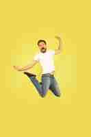 Free photo full length portrait of happy jumping man isolated on yellow