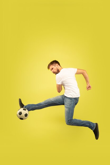 Full length portrait of happy jumping man isolated on yellow