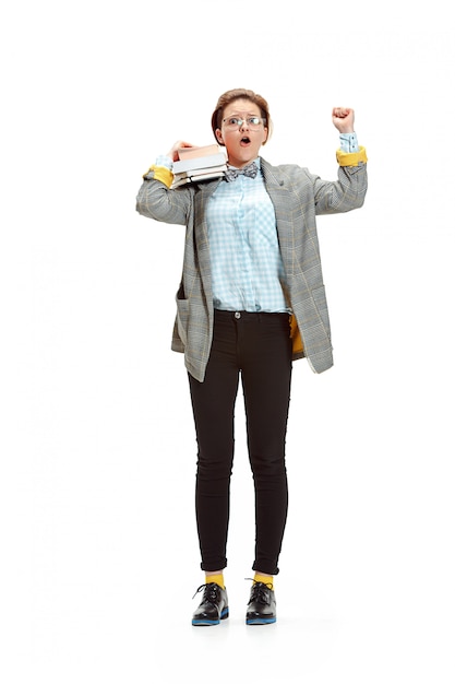 Full length portrait of a happy smiling female student holding books isolated on white space