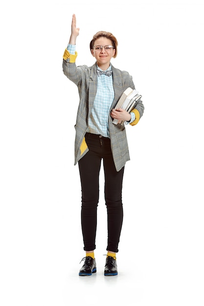 Full length portrait of a happy smiling female student holding books isolated on white space