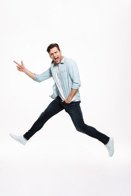 Full length portrait of a joyful happy man jumping