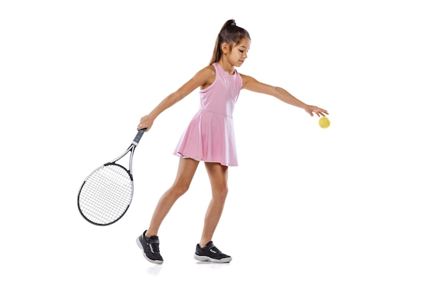 Full-length portrait of little girl training, playing tennis