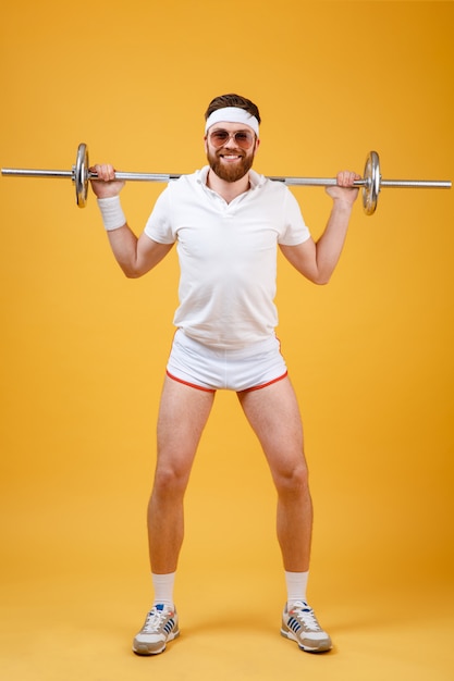 Full length portrait of a man athlete exercising with barbell