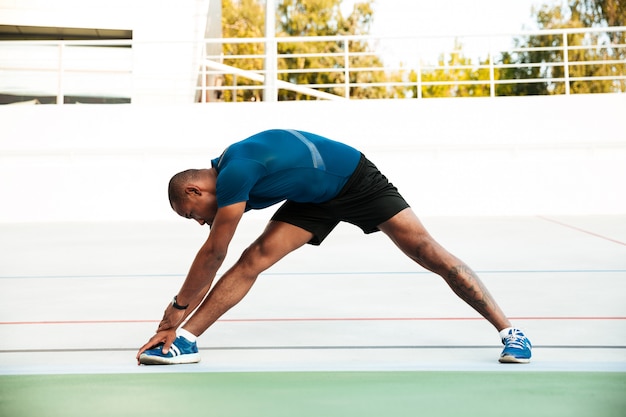 Full length portrait of a motivated sportsman doing stretching