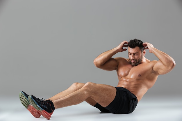 Full length portrait of a muscular fit shirtless male bodybuilder